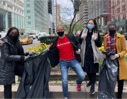 Santander employees posing in a city while picking up garbage