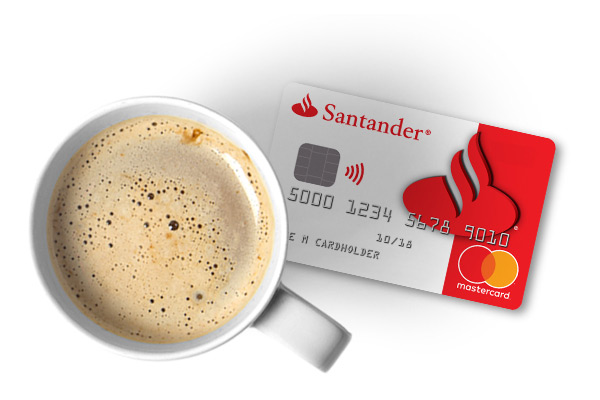 A cup of coffee on a table with a Santander bank debit card