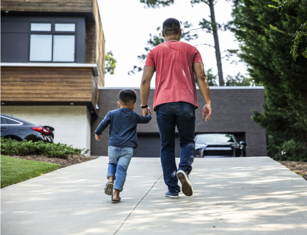 Man walking with small child holding hands