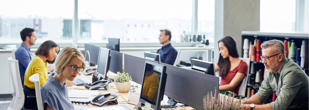 People working on computers in an open-office environment