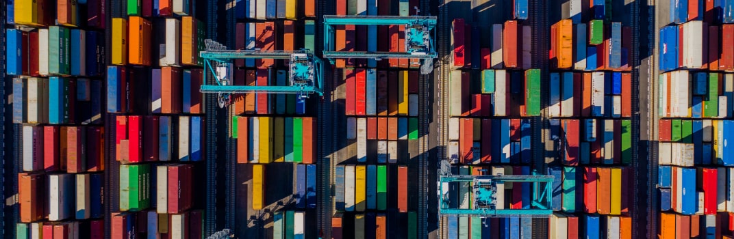 A bird's-eye view of a lot full of shipping containers of various colors.
