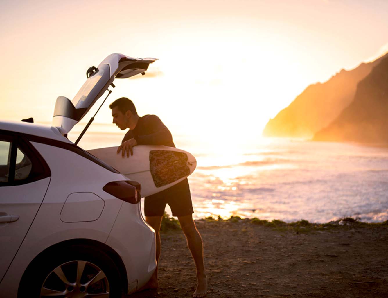 Man putting away surfboard in early morning