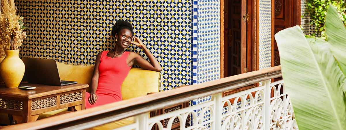 Woman sitting in upscale exotic hotel looking out towards balcony