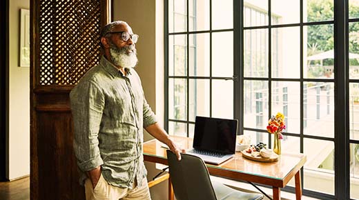 A man standing in a room looking out a window