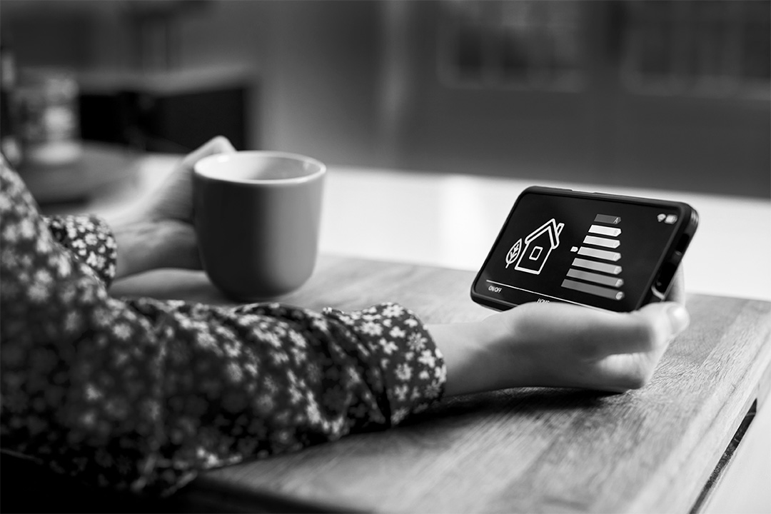 Person looking at phone while drinking coffee.