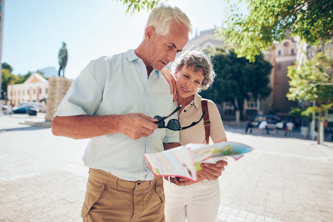 A man and woman looking at a map outdoors.