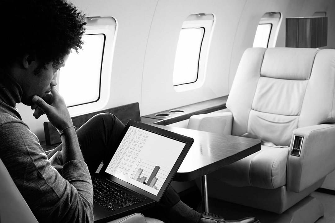 Person looking at laptop on a plane