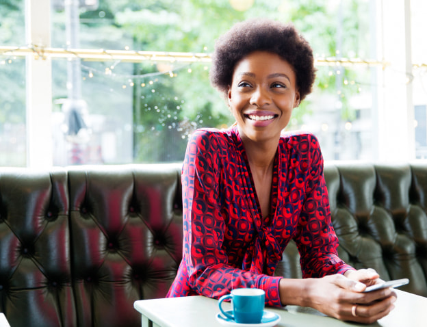 Woman sitting in a coffee shop smiling