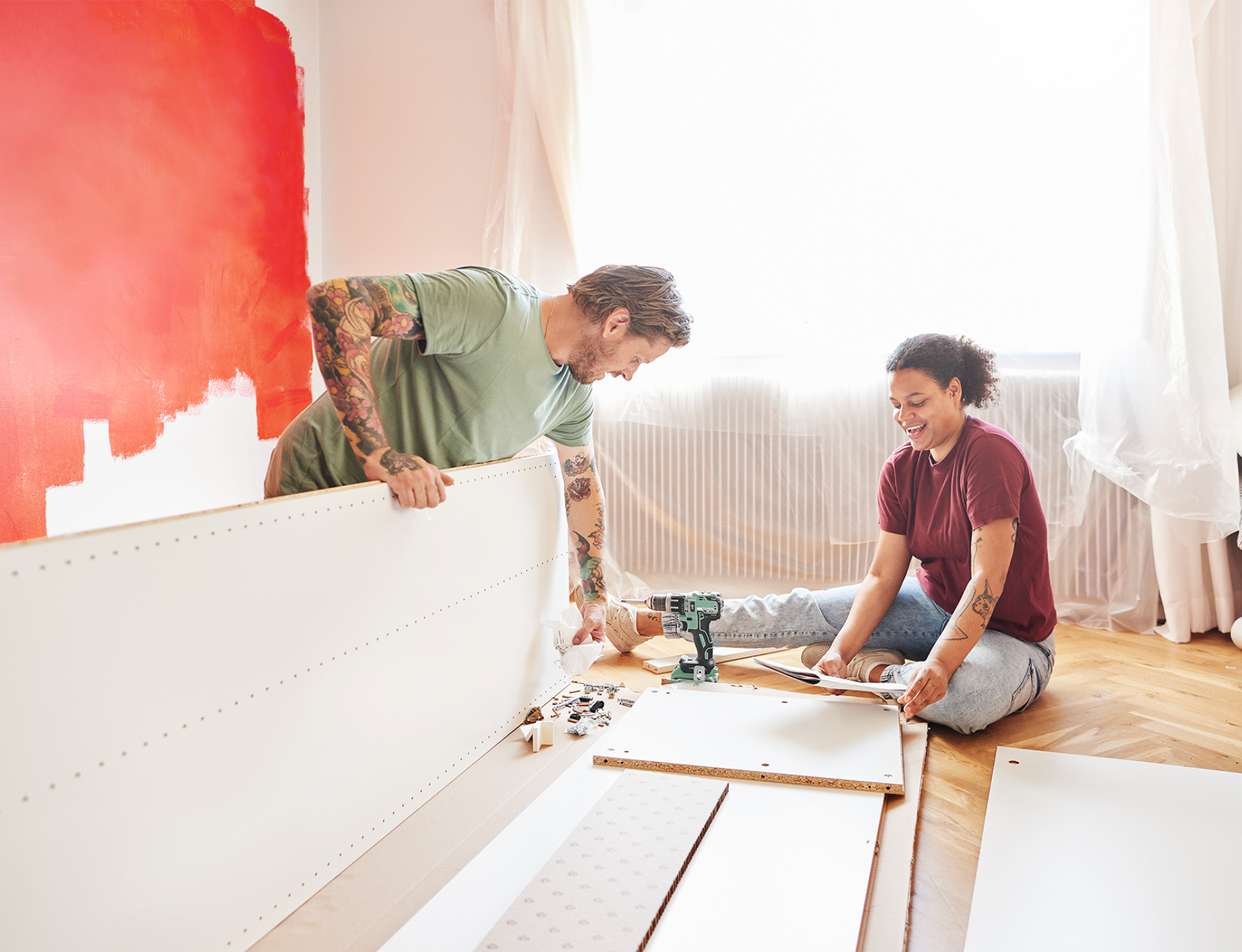 man and woman renovating a room in their home, building a piece of furniture
