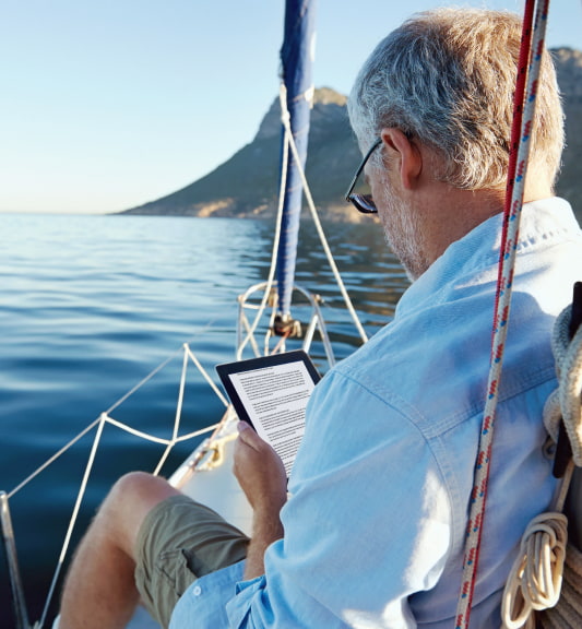An older aged man reading on a yacht