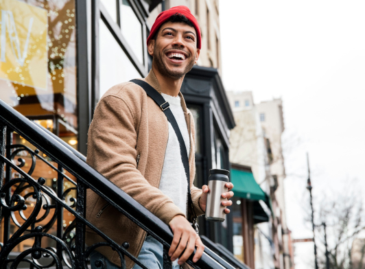 Man smiling, standing on stairs of a building