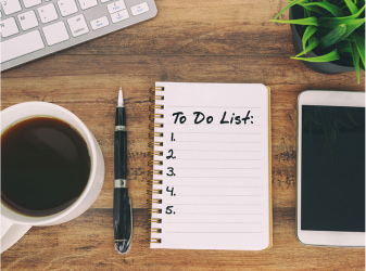 Coffee, pen, and to-do list on a wooden table