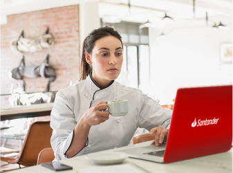 Woman drinking espresso in front of red laptop