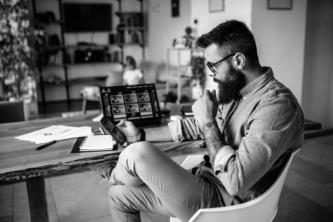 a man sitting at a table looking at a tablet